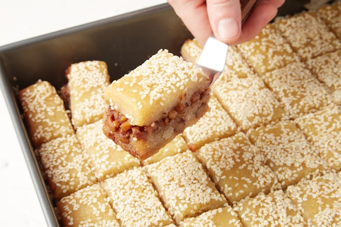 Tishpishti sliced into small portions in baking pan.