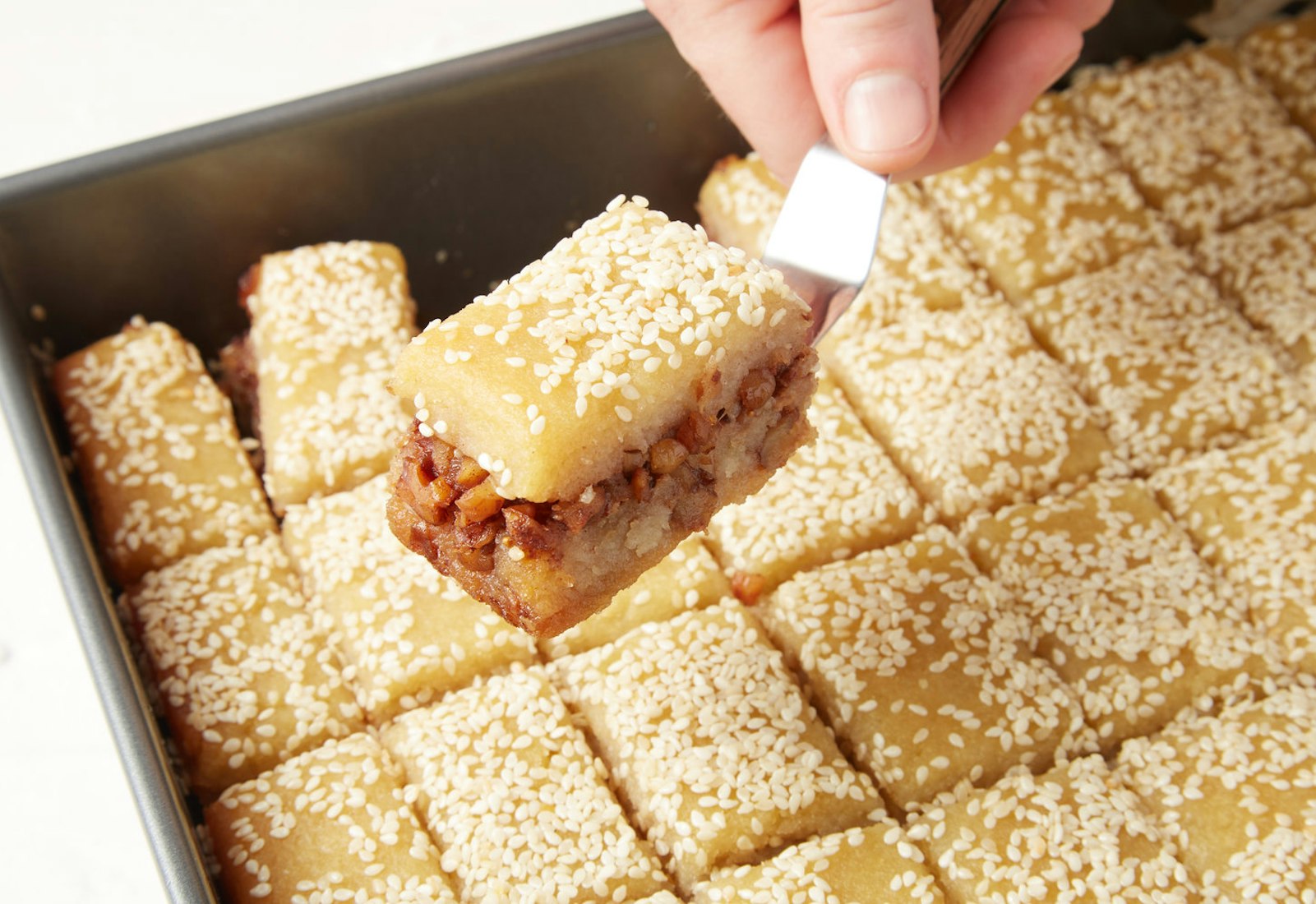 Tishpishti sliced into small portions in baking pan.