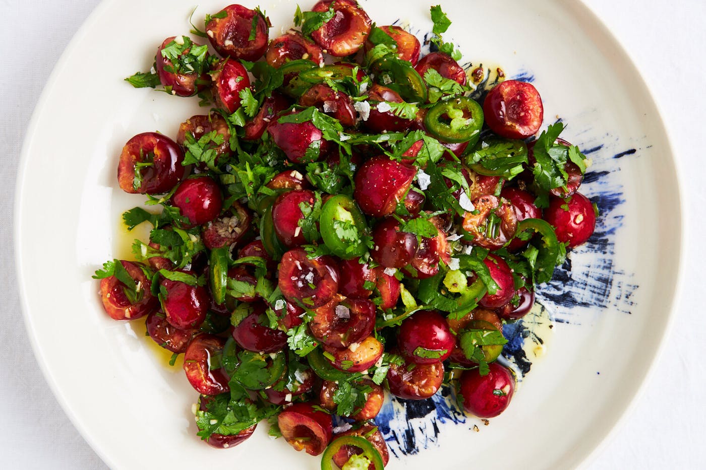 Lali salad on blue and white plate atop white surface. 