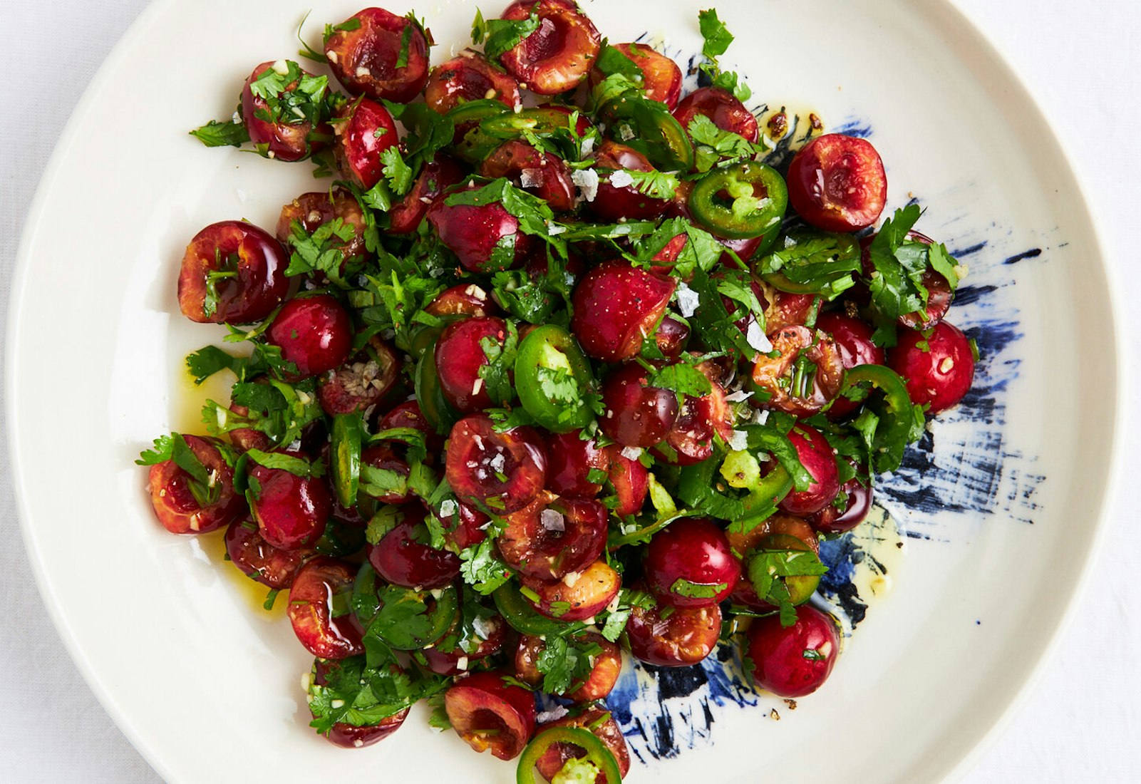 Lali salad on blue and white plate atop white surface.