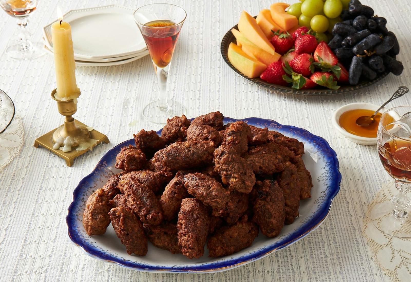 Pizarelle with honey, red wine and fresh fruits, candle.