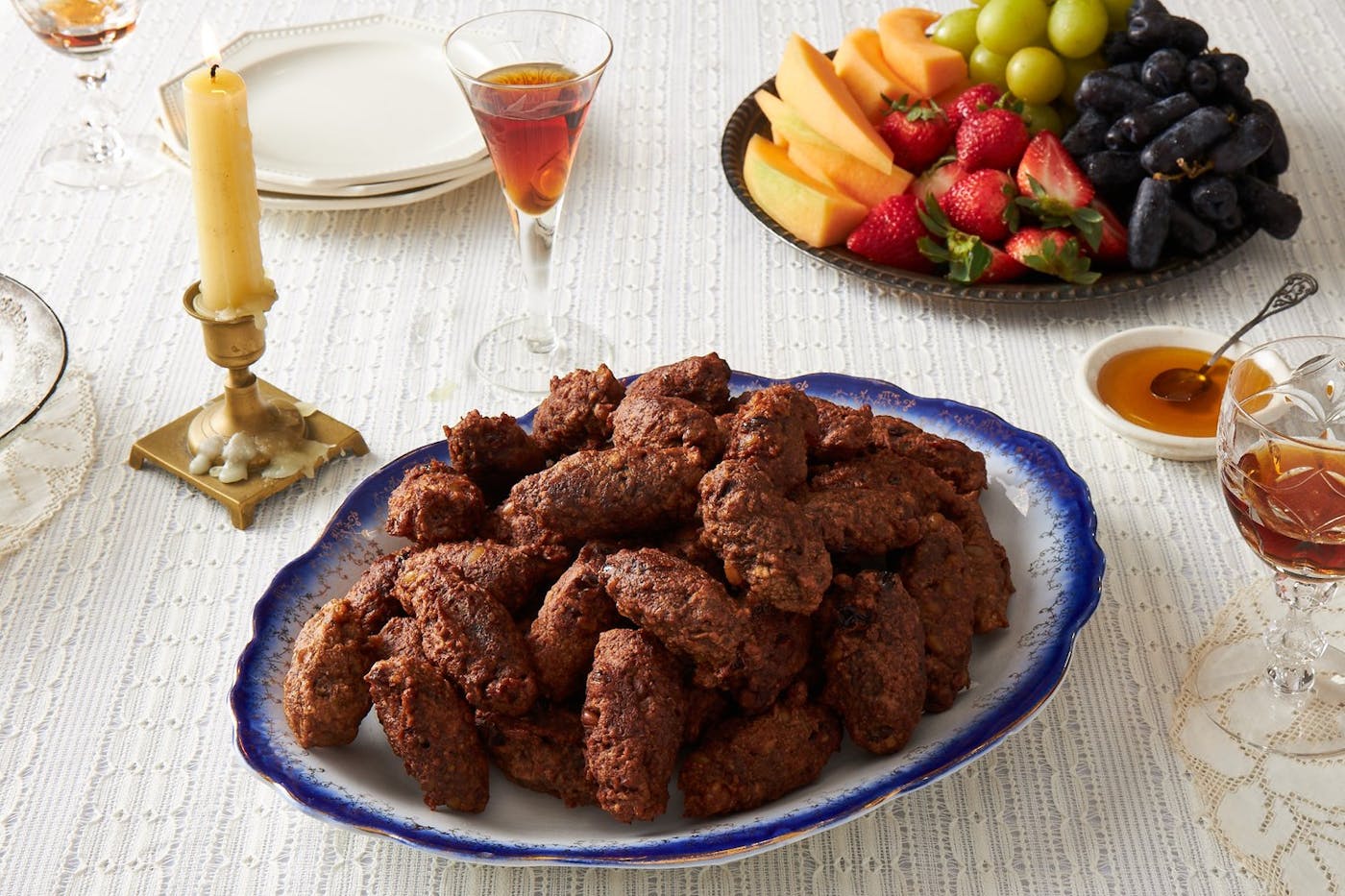 Pizarelle with honey, red wine and fresh fruits, candle.