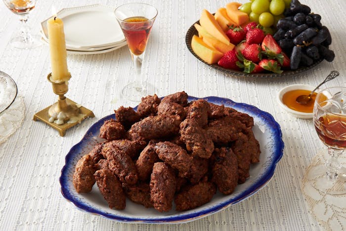 Pizarelle with honey, red wine and fresh fruits, candle.