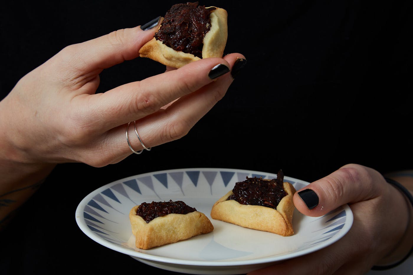 Person holding plate with hamantaschens.