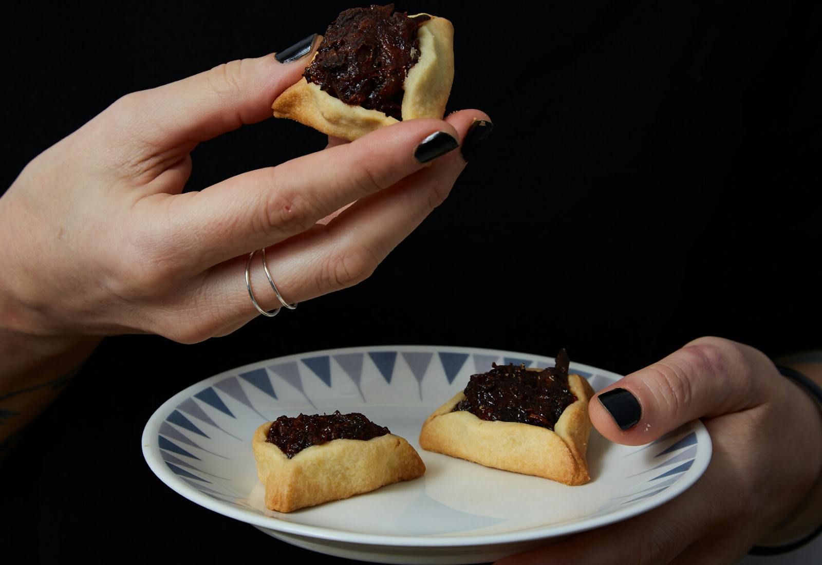 Person holding plate with hamantaschens.