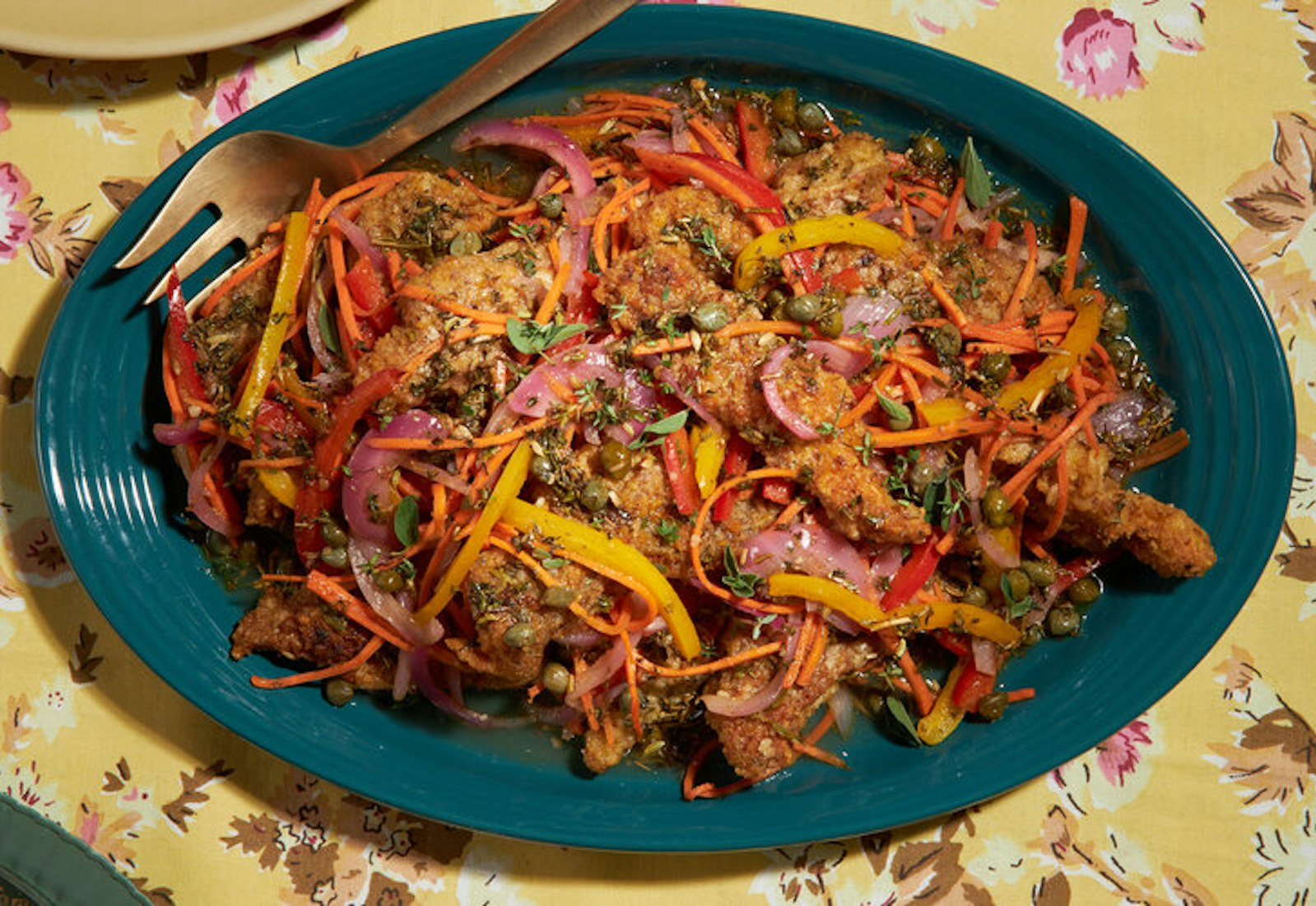 Rojitos fritos on blue platter atop yellow floral tablecloth.