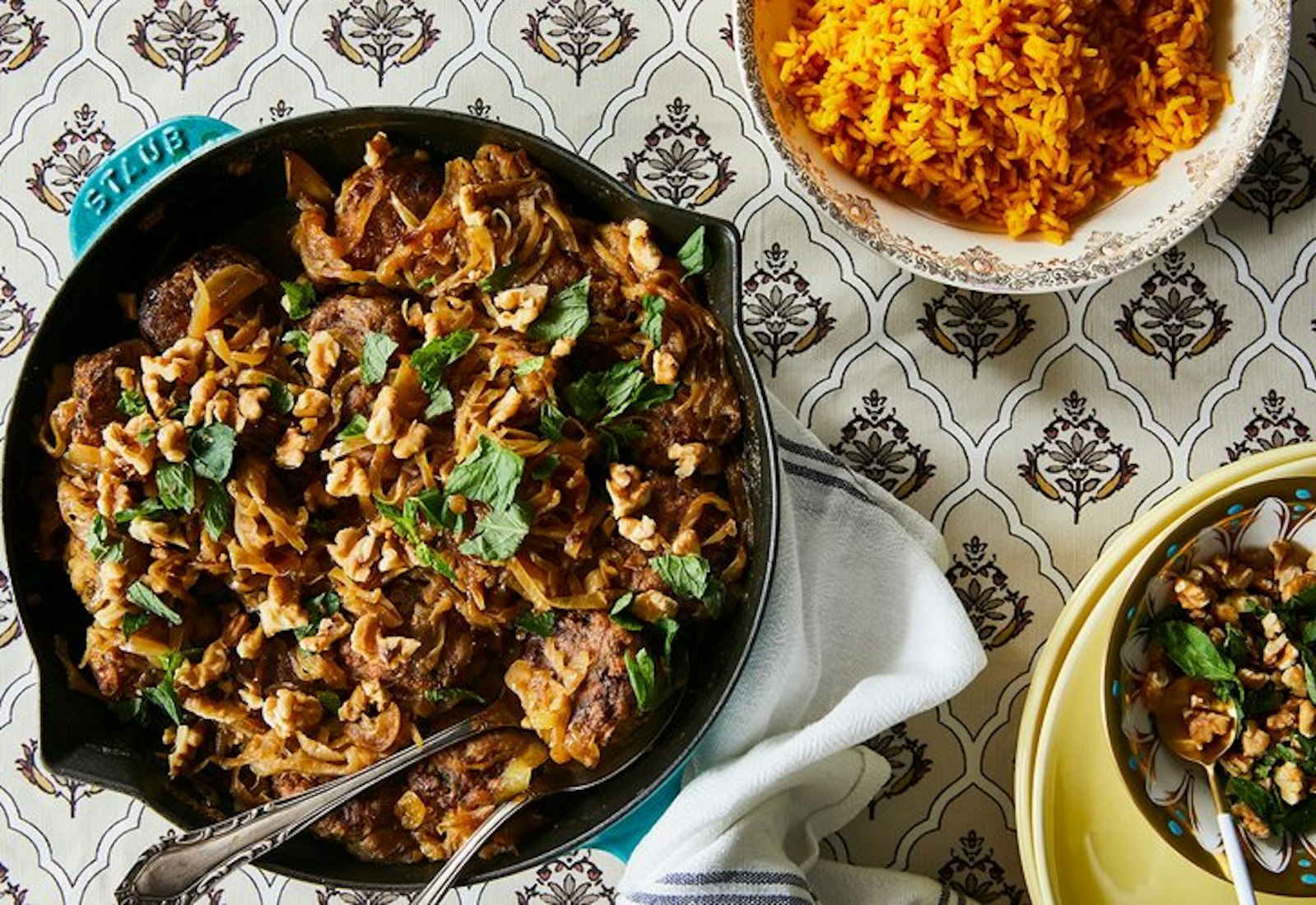 Meatballs garnished with mint and walnuts, side of yellow rice.