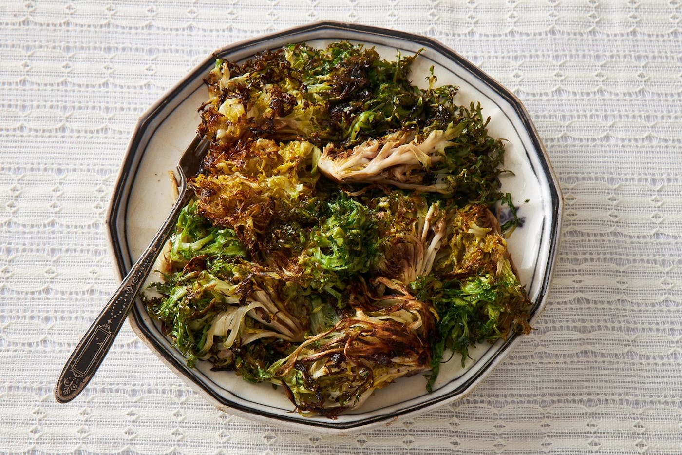 Toasted frisée on black and white plate.