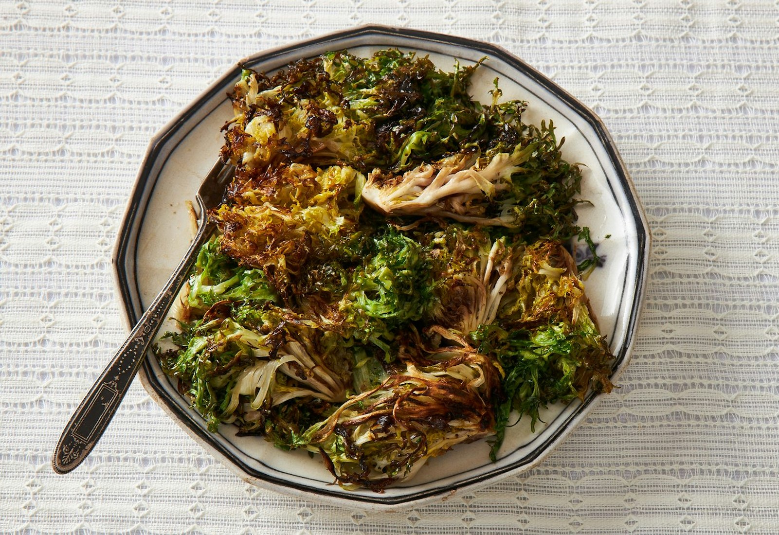 Toasted frisée on black and white plate.