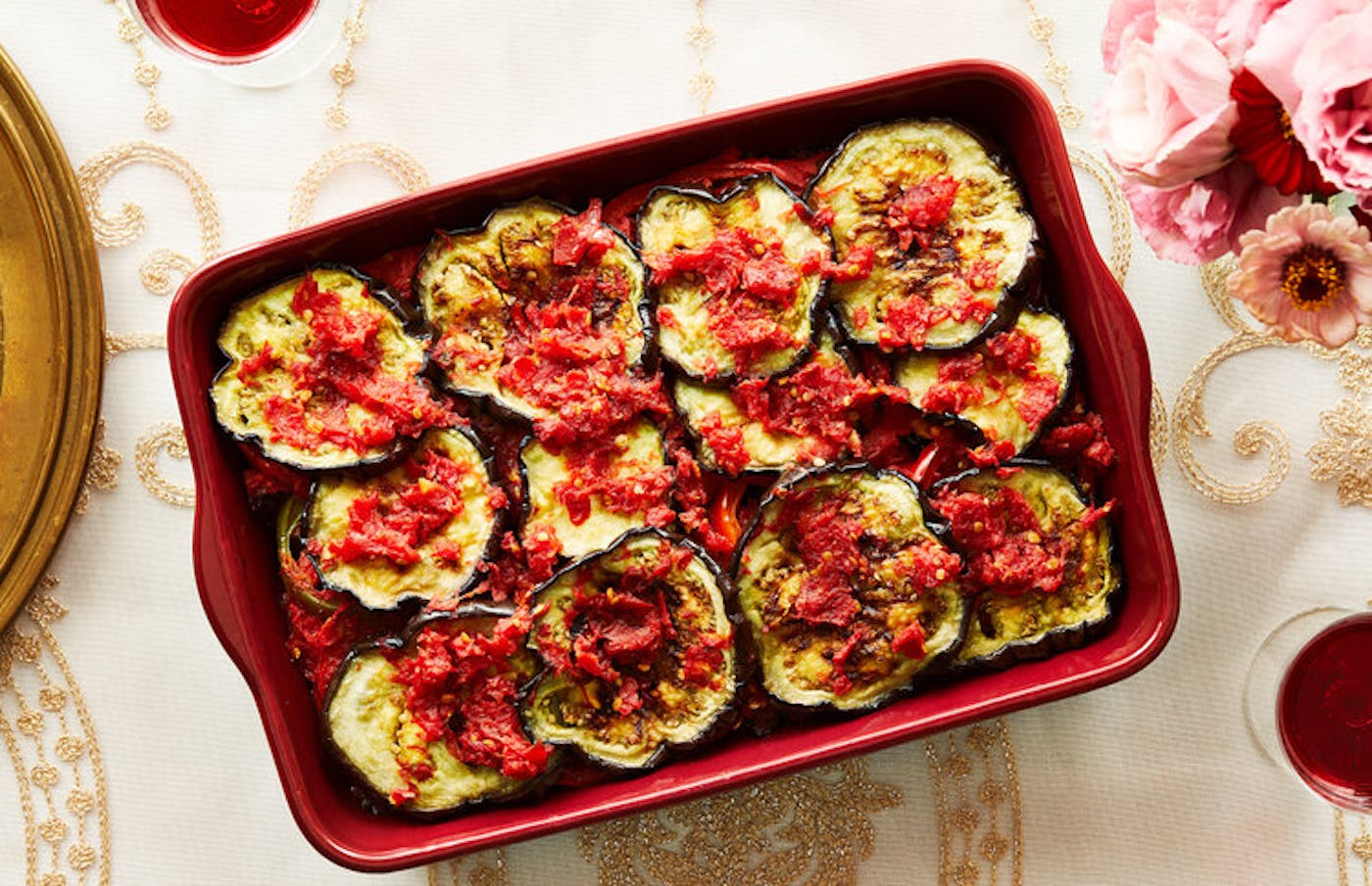 Ingriye in red roasting pan, pink flowers and red wine.