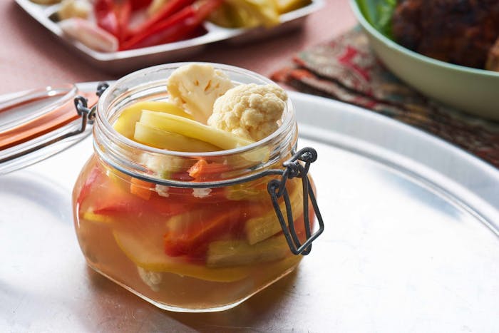 Turshi in jar on metal tray.