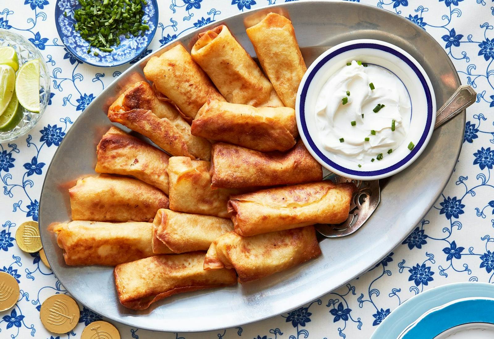 Blintzes with sour cream and chives, cilantro, limes, chocolate gelt.