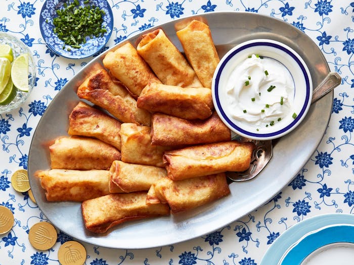 Blintzes with sour cream and chives, cilantro, limes, chocolate gelt.