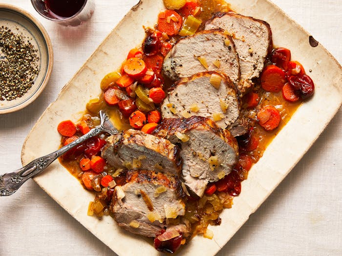 Sliced veal over wine-braised carrots, celery, onion and tomato on serving platter.