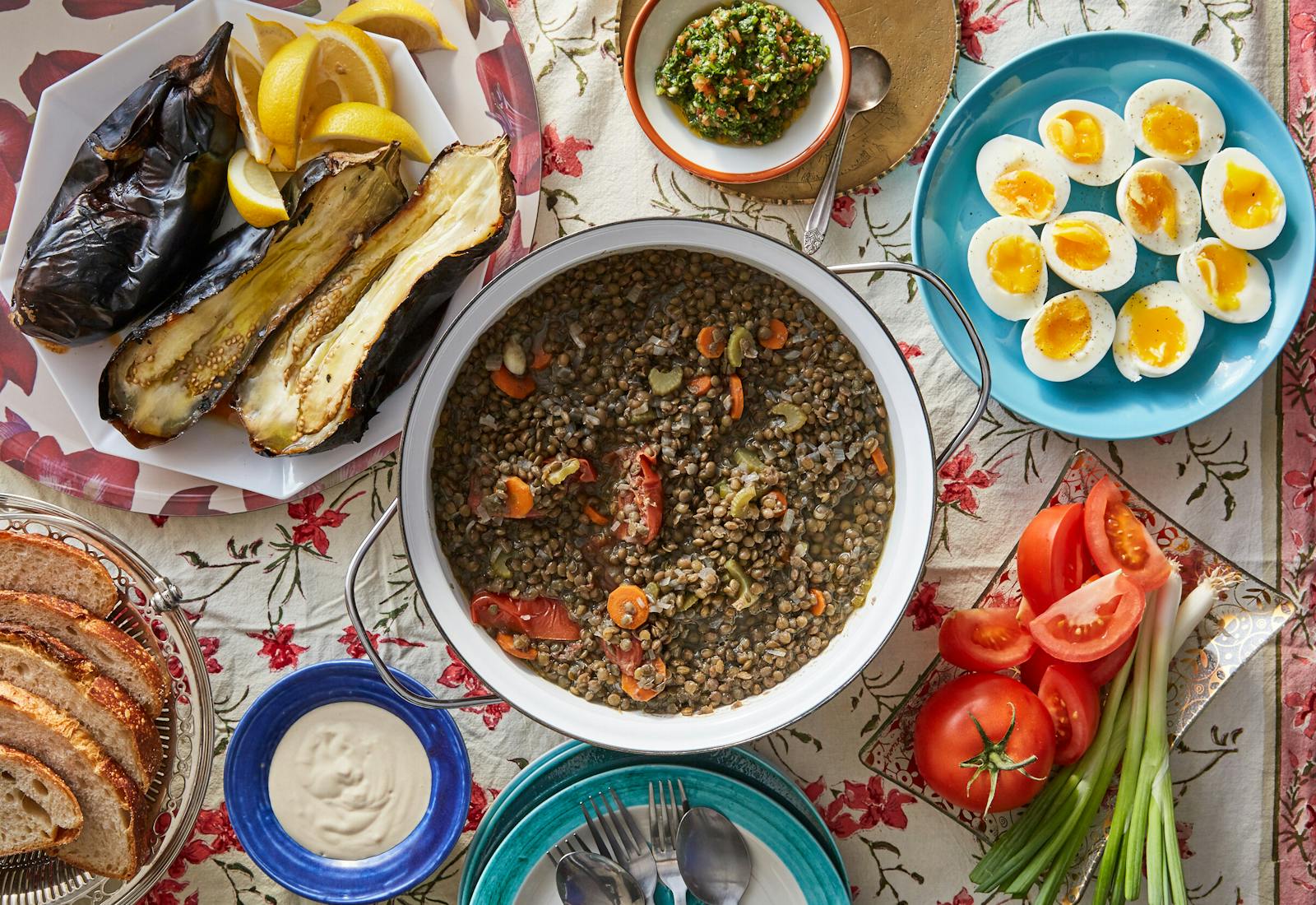 Lentil stew alongside roasted eggplants, eggs, bread