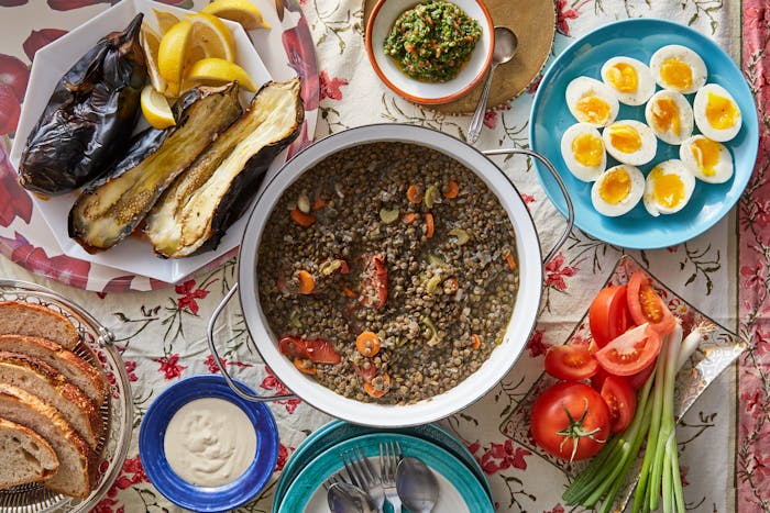 Lentil stew alongside roasted eggplants, eggs, bread