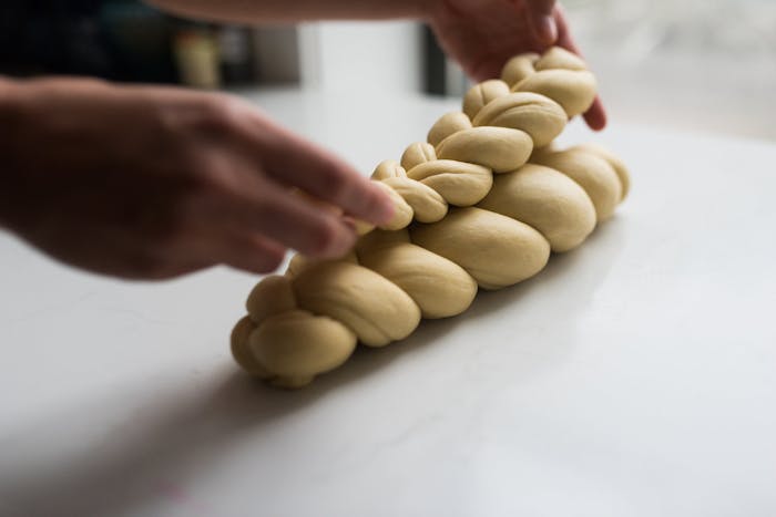 Chef preparing layered challah braids to bake. 