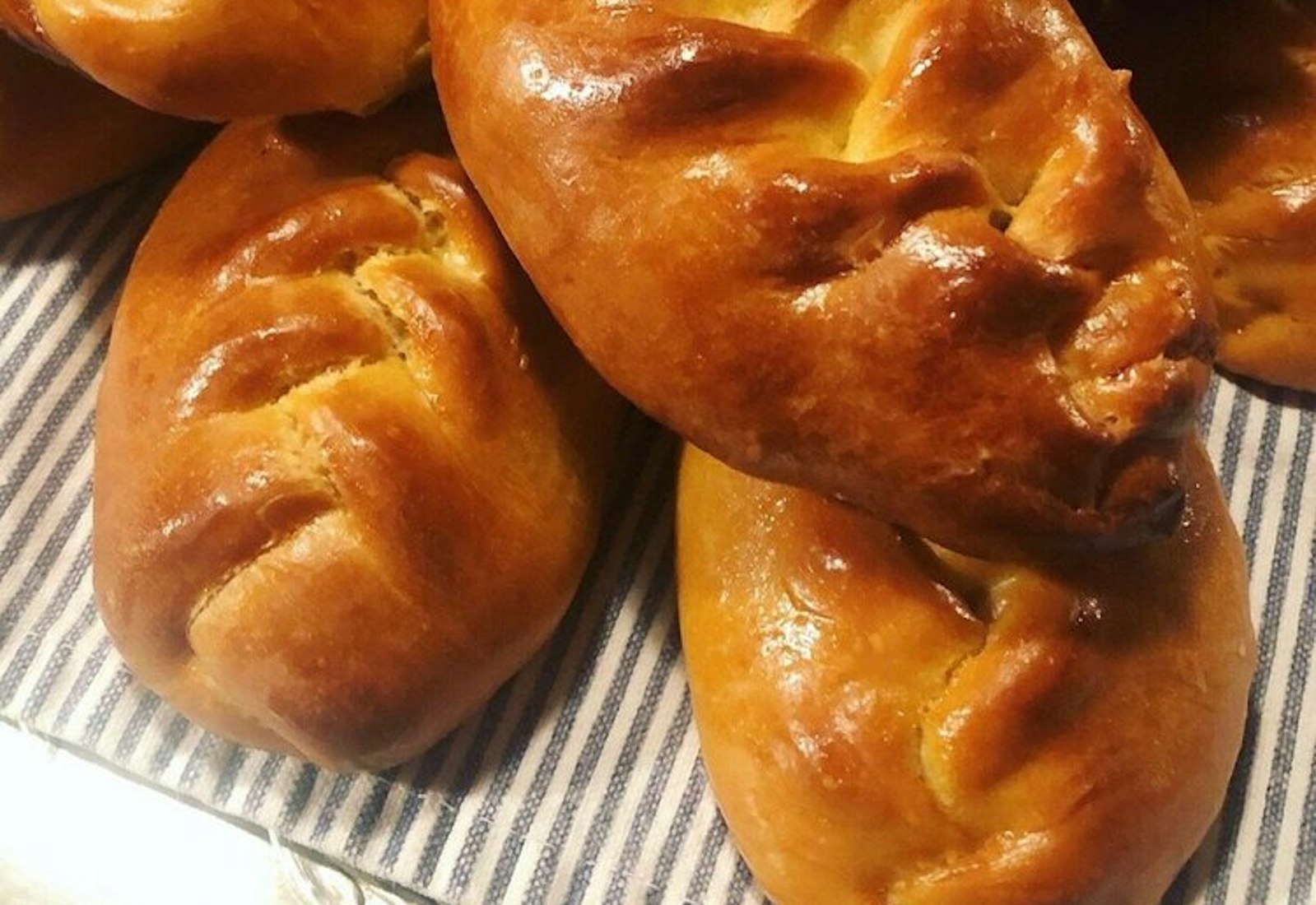 Pirozhki piled atop tablecloth.