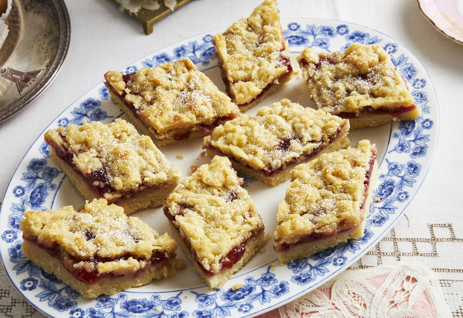 Jam crumble bars on blue floral plate.