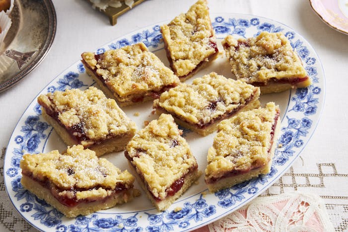 Jam crumble bars on blue floral plate.