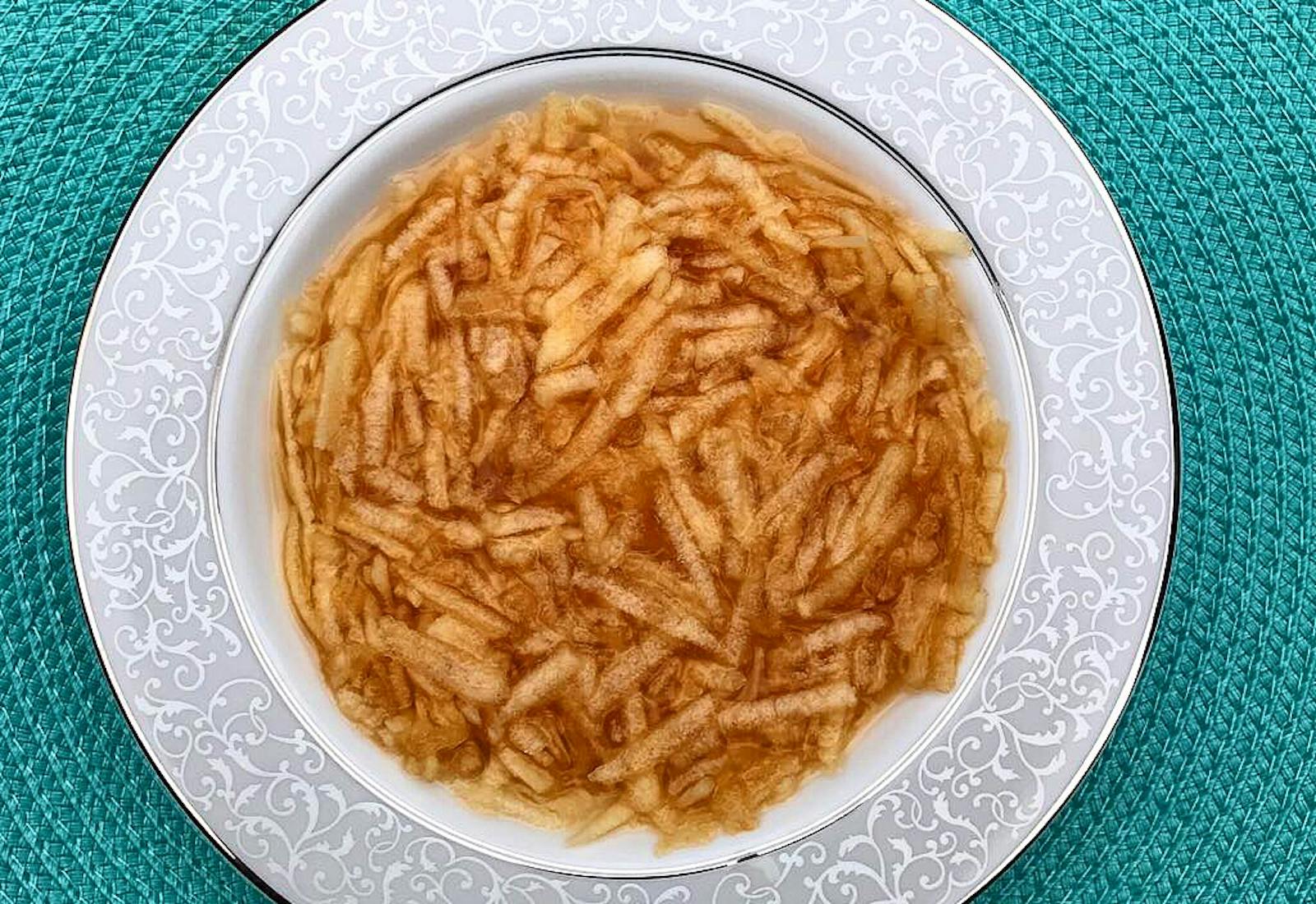 Faloodeh in grey bowl atop blue woven placemat. 