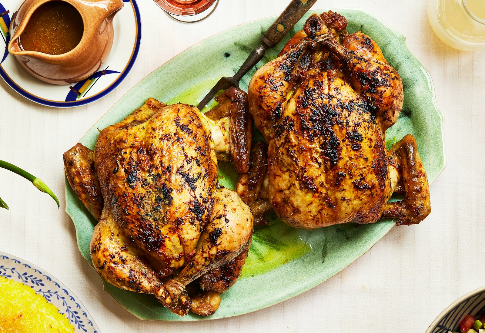 Saffron roast chicken alongside carafe of jus.
