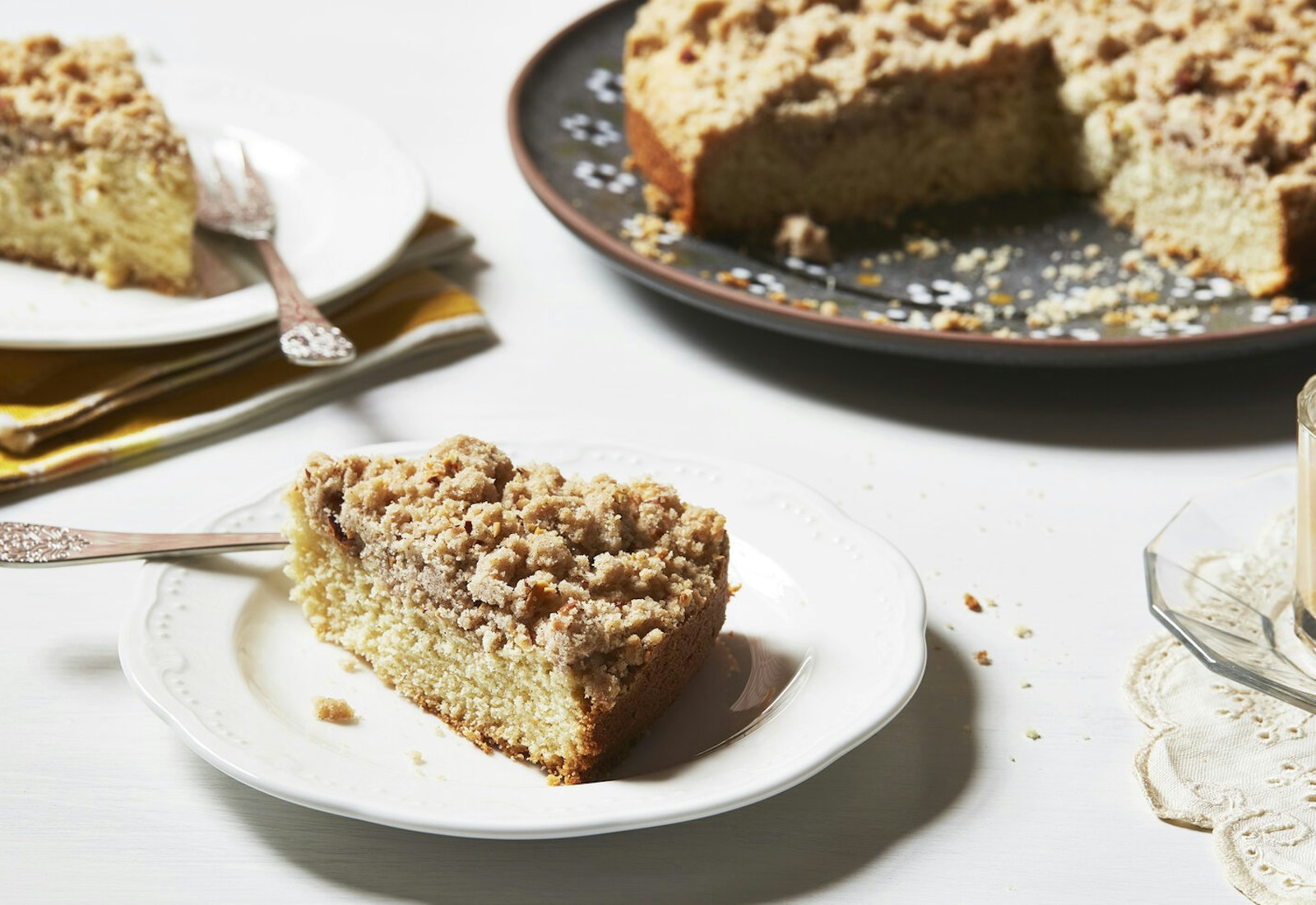 Tray of cake with two slices cut out, mug of coffee.