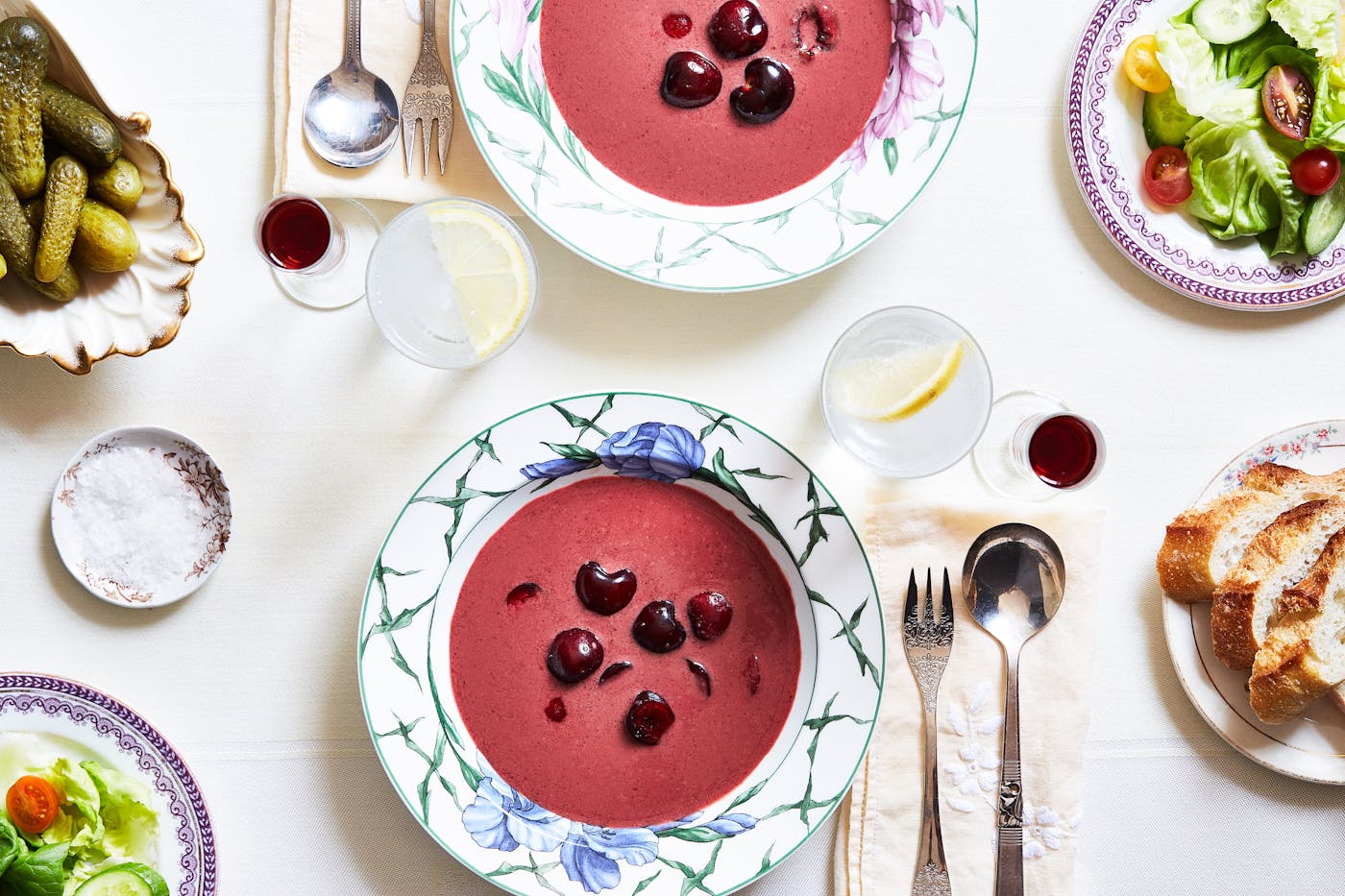 Chilled fruit soup served in two white and blue bowls atop a white tablecloth.