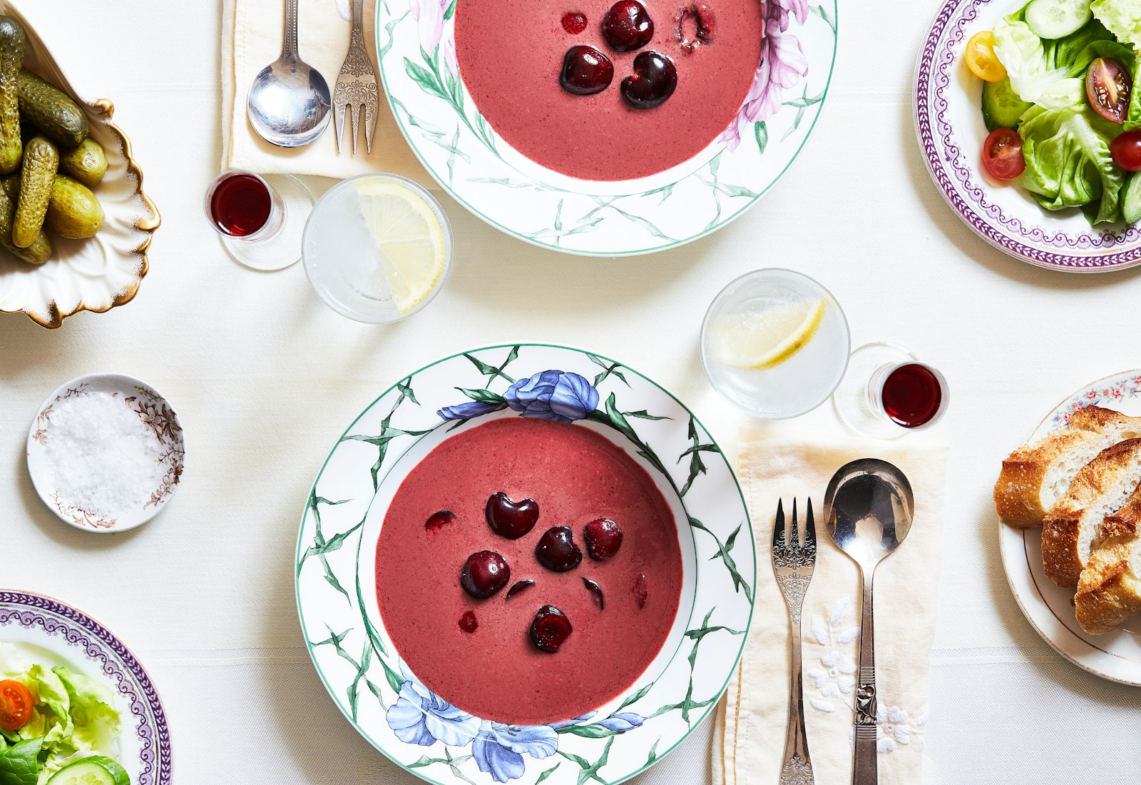 Chilled fruit soup served in two white and blue bowls atop a white tablecloth.