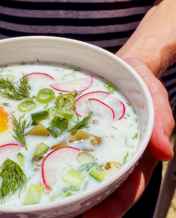 Sasha holding a bowl of okroshka.