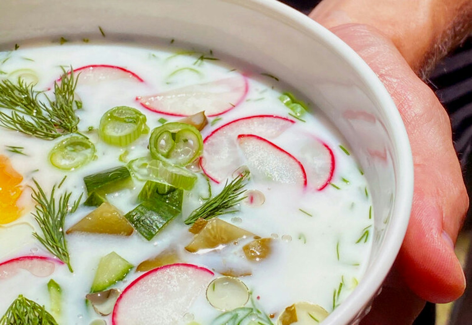 Sasha holding a bowl of okroshka.