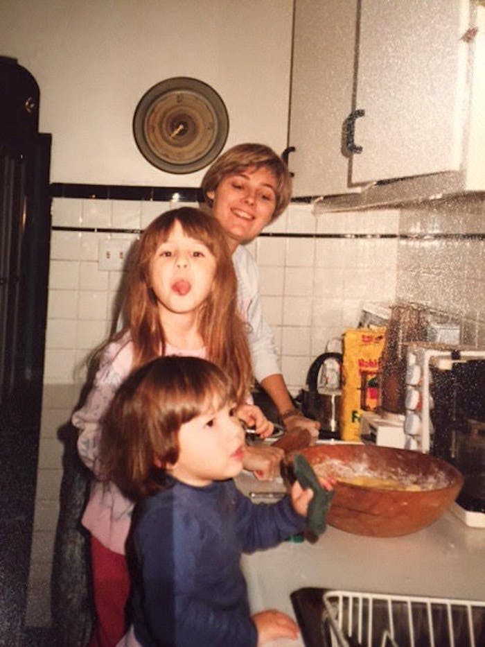 Eden and her sister in the kitchen with their mother.