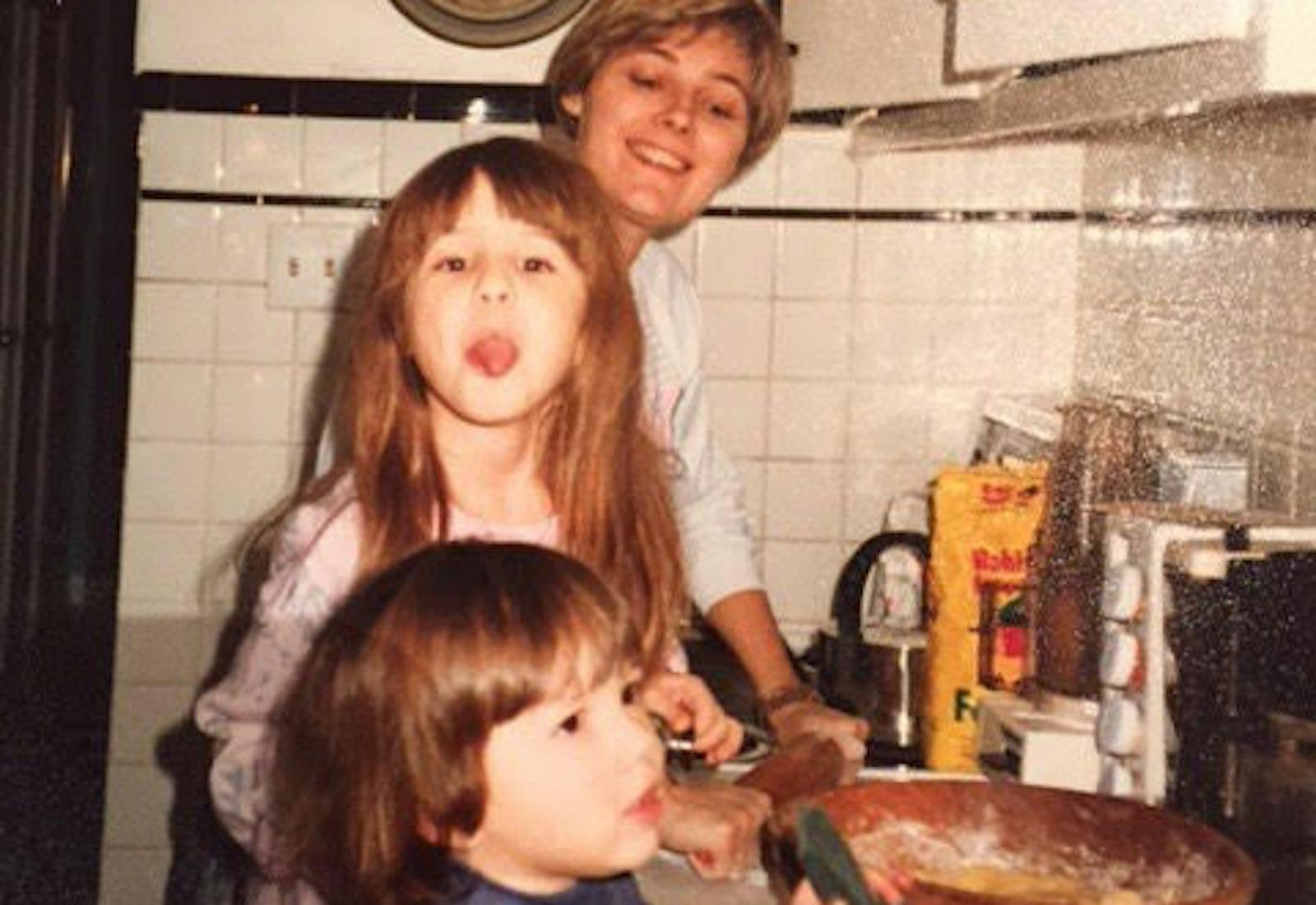 Eden and her sister in the kitchen with their mother.