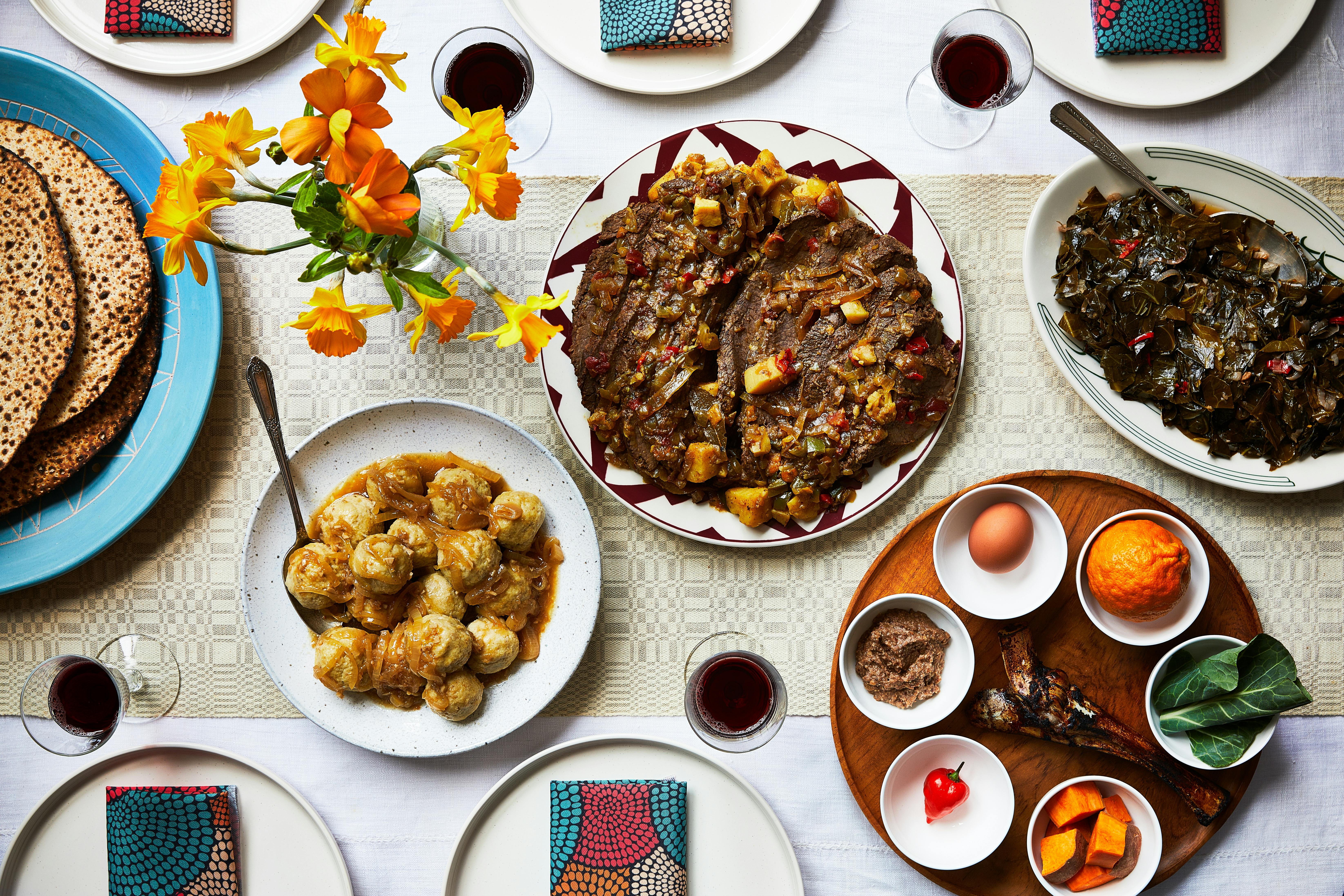 West African Passover tablespread with brisket, collards, kneidlach in yassa sauce, matzah and seder plate.
