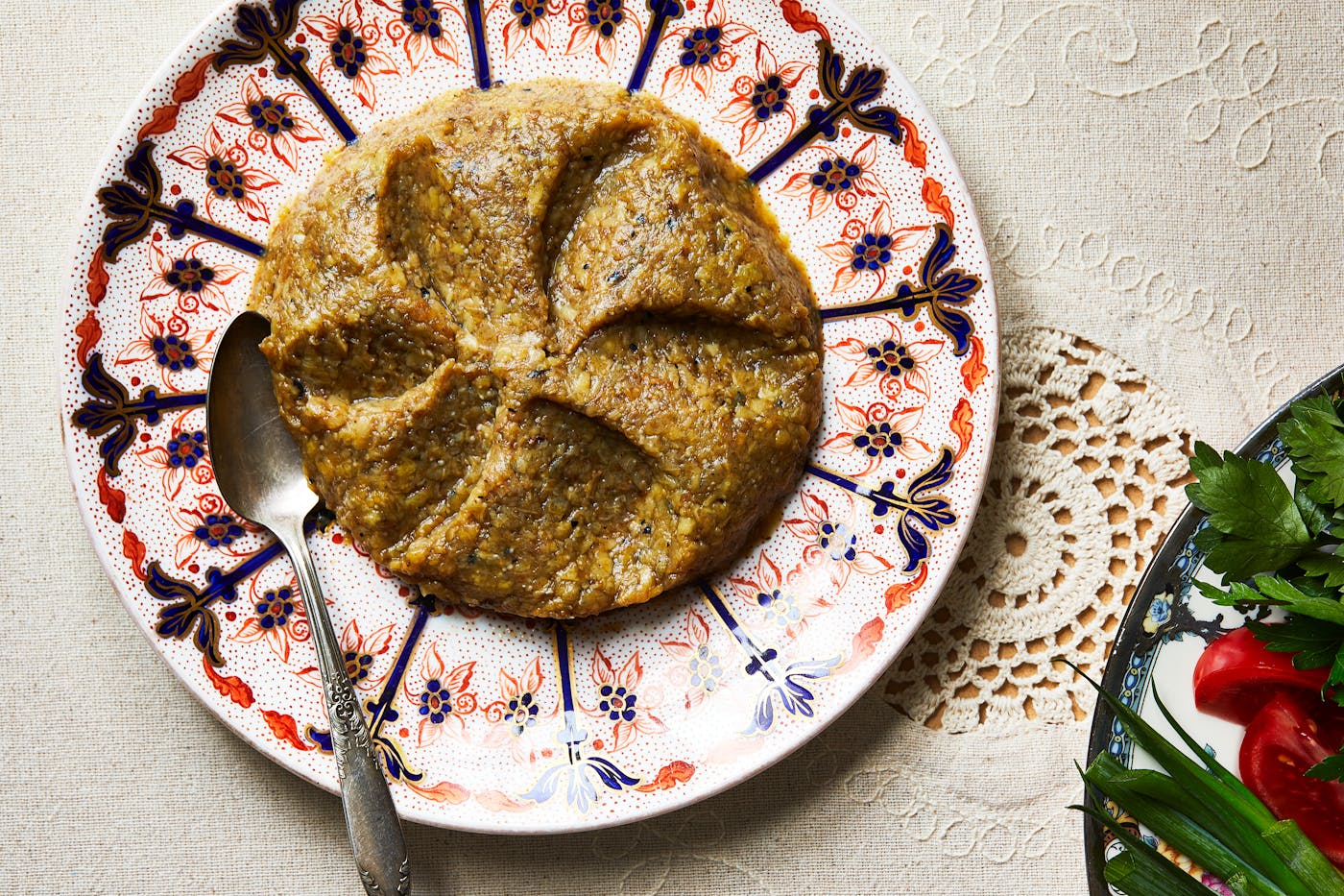 Roasted eggplant dip spread on serving plate with silver spoon.
