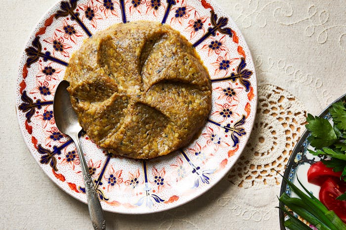 Roasted eggplant dip spread on serving plate with silver spoon.