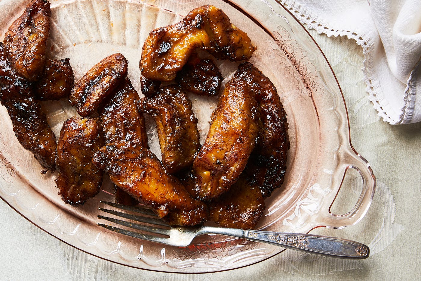 Fried sweet plantains served on light pink platter.