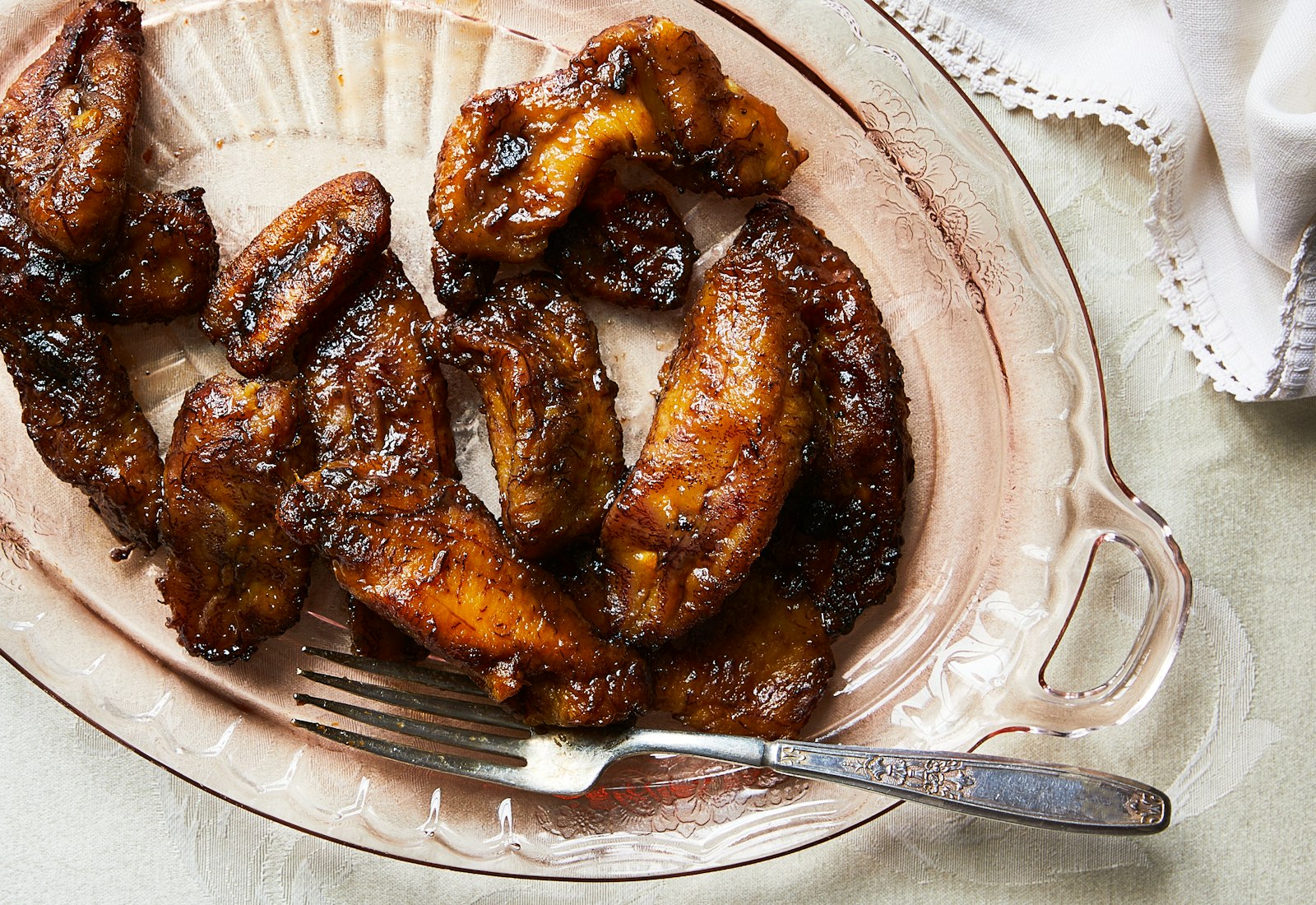 Fried sweet plantains served on light pink platter.
