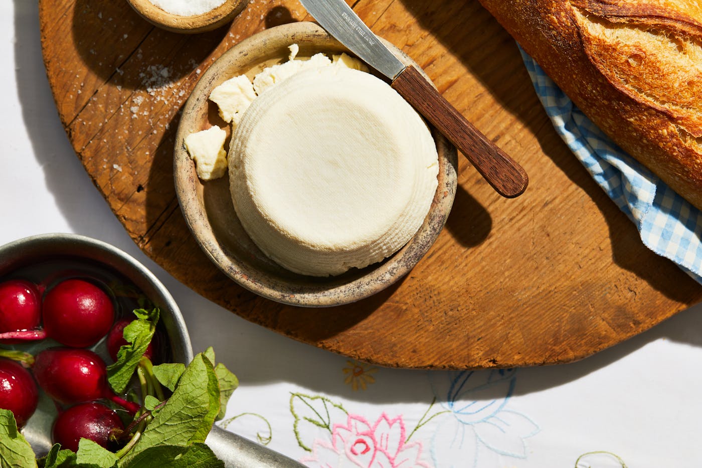 J'ben on small serving dish over wooden cutting board, next to radishes and baguette.