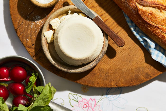 J'ben on small serving dish over wooden cutting board, next to radishes and baguette.