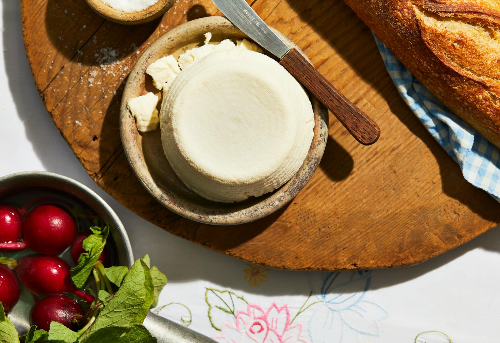 J'ben on small serving dish over wooden cutting board, next to radishes and baguette.