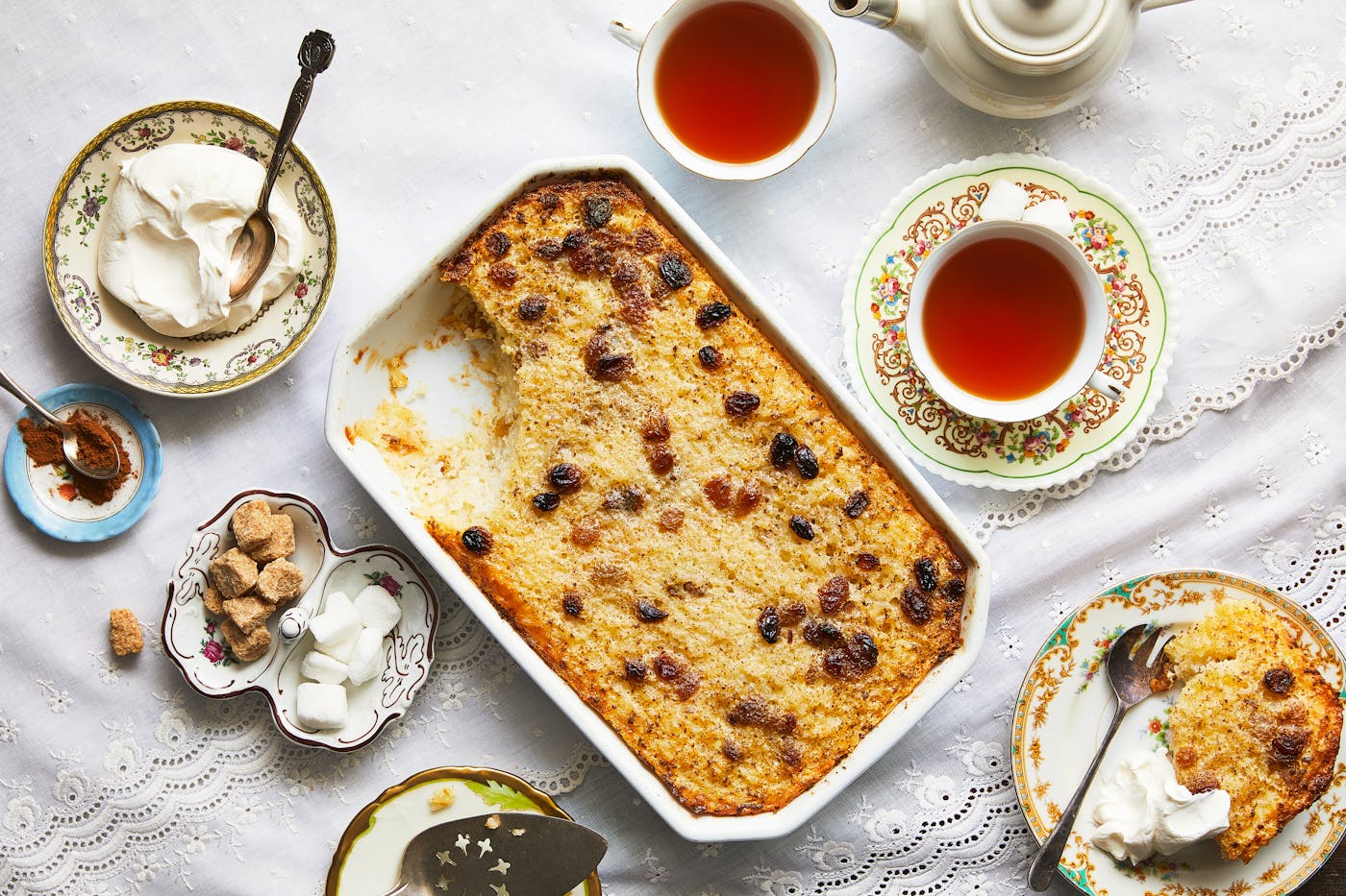 Rice kugel with large spoonful taken out and sour cream and tea alongside.