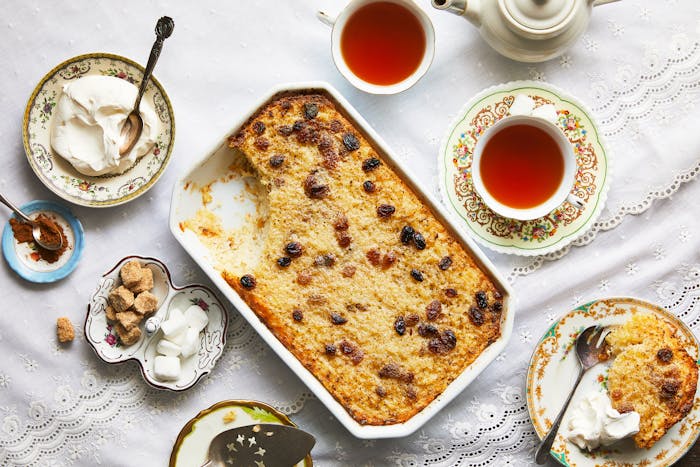 Rice kugel with large spoonful taken out and sour cream and tea alongside.