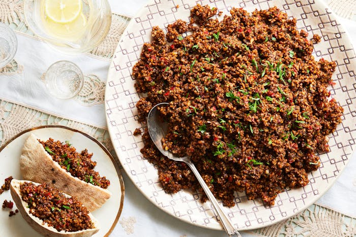 Bulgur and tamarind salad in a large bowl with pita on the side.