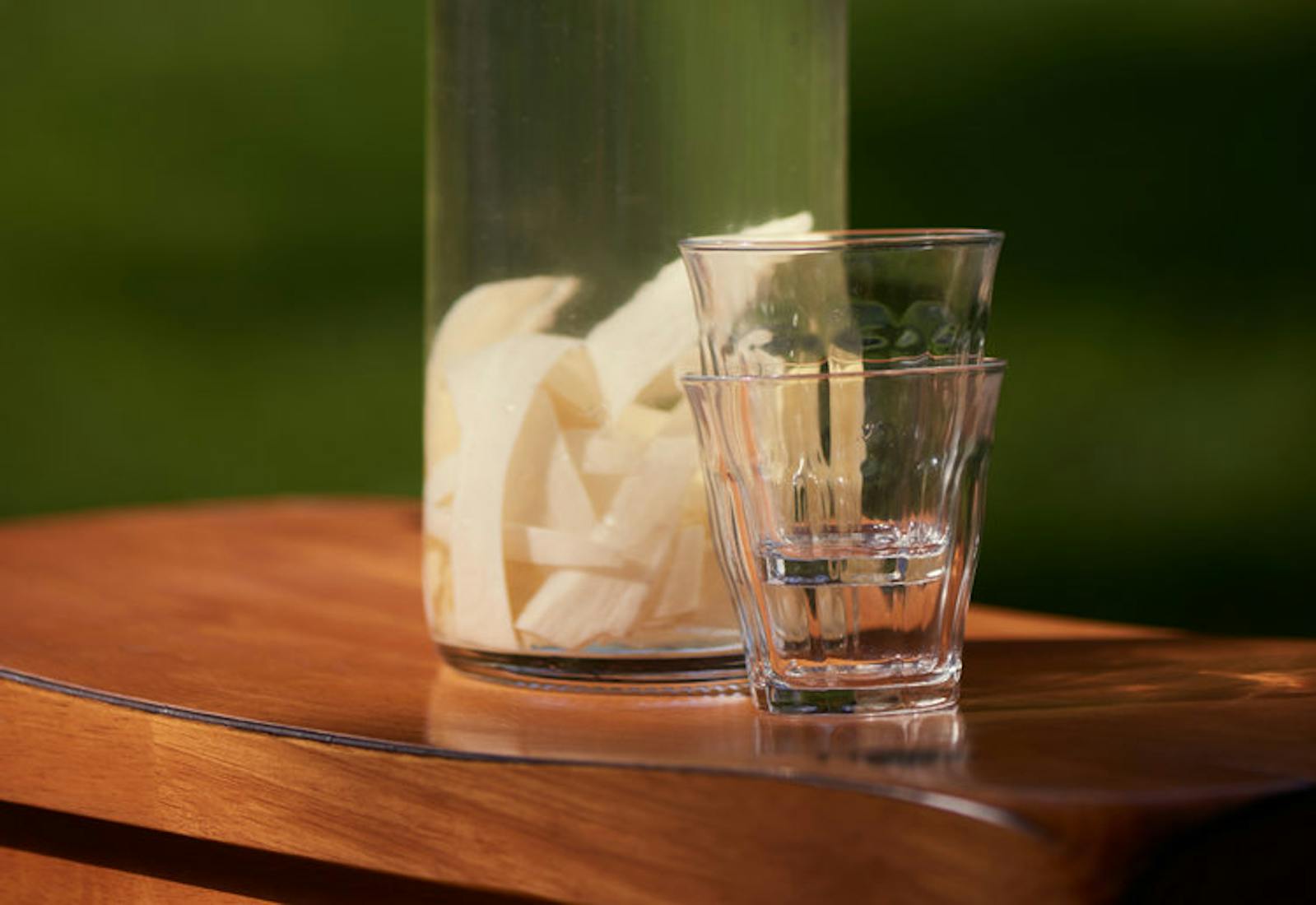 Horseradish vodka in bottle on wooden table.