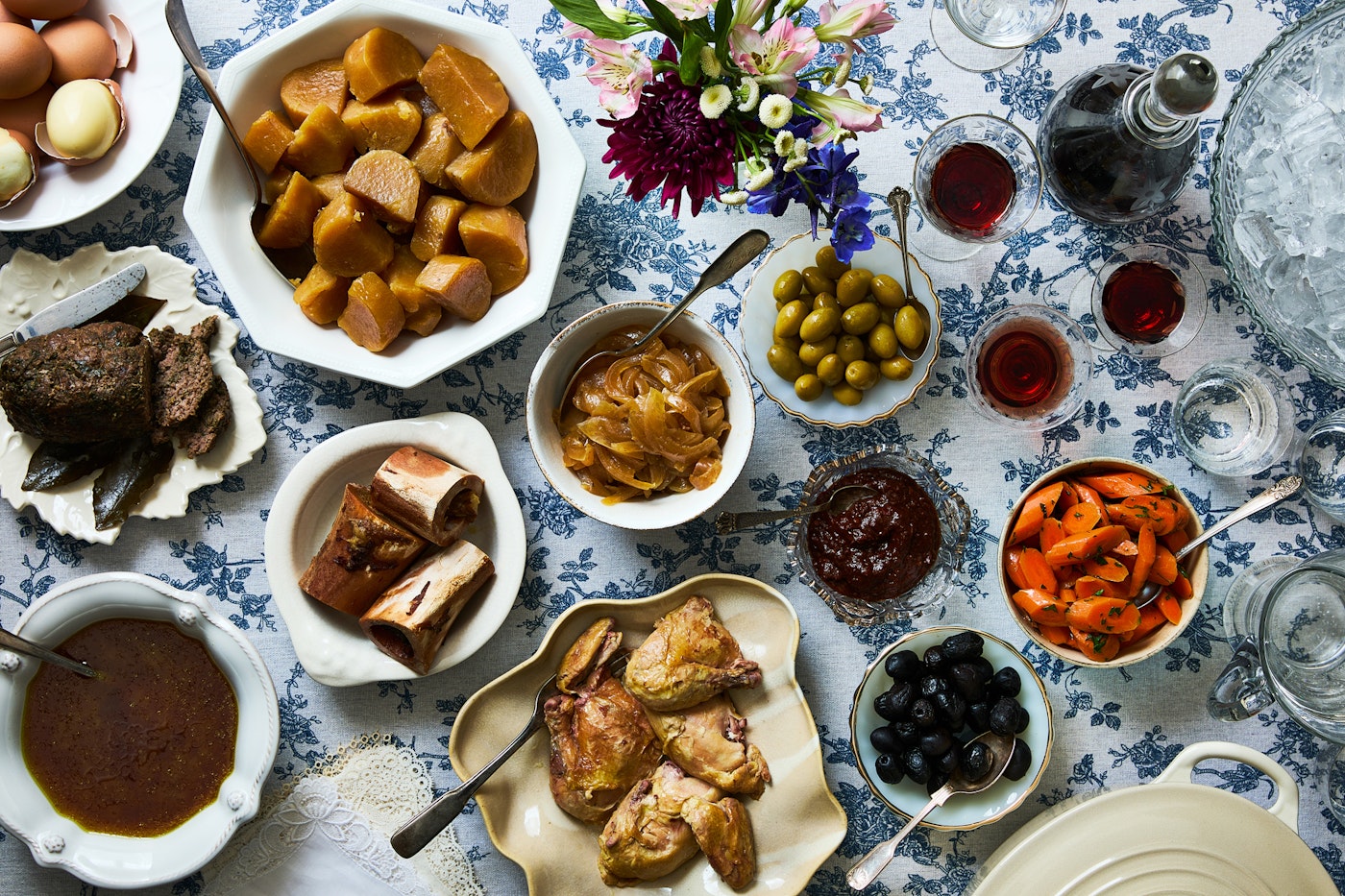 Table with Dafina and salads in serving bowls
