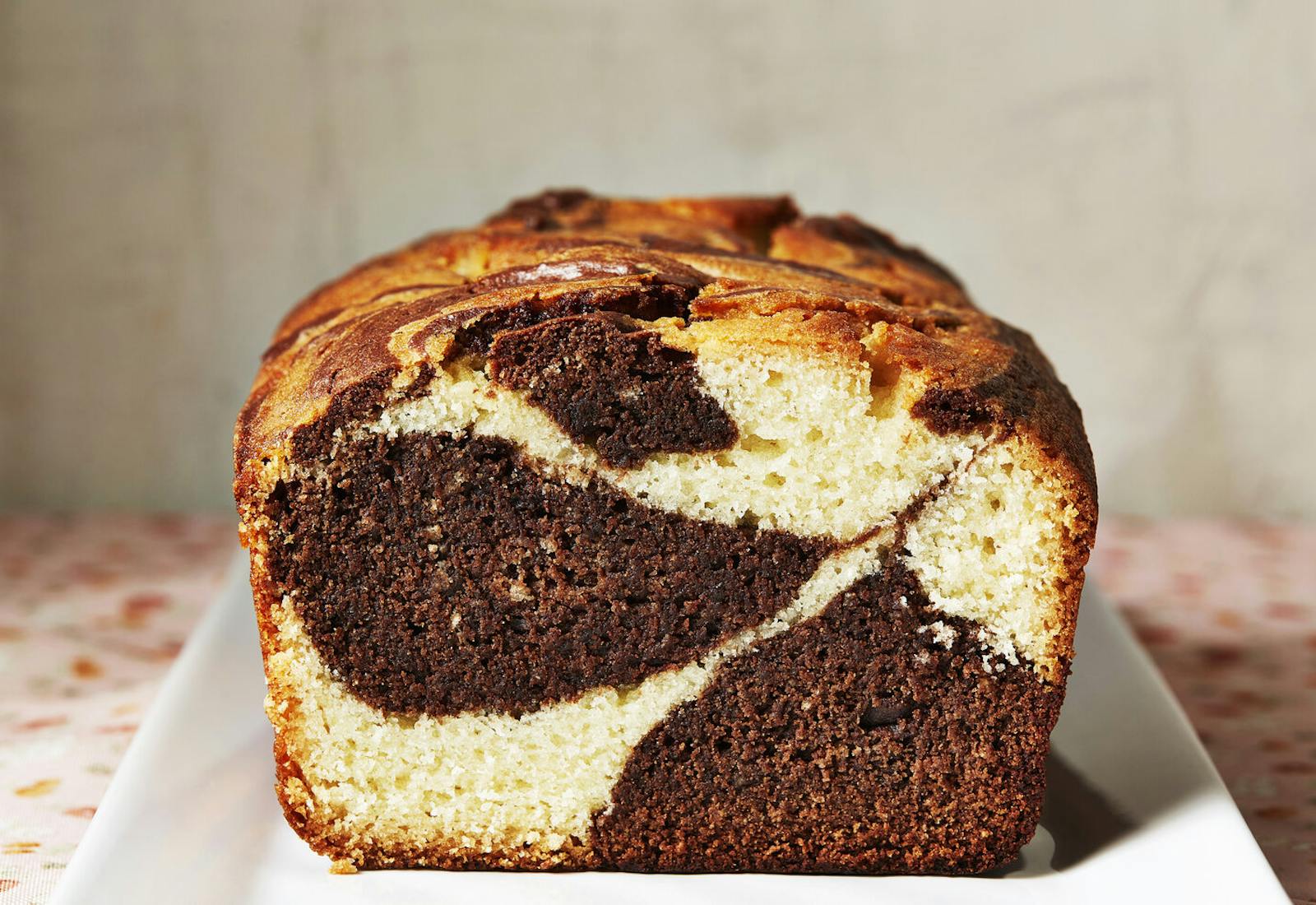 Coconut marble loaf cut in half on white plate.