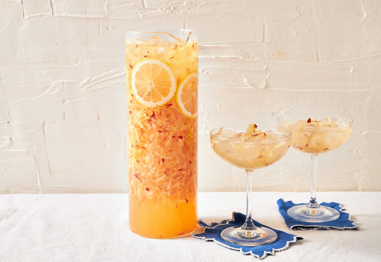 Faloodeh in glass pitcher with two margarita glasses on blue napkins.