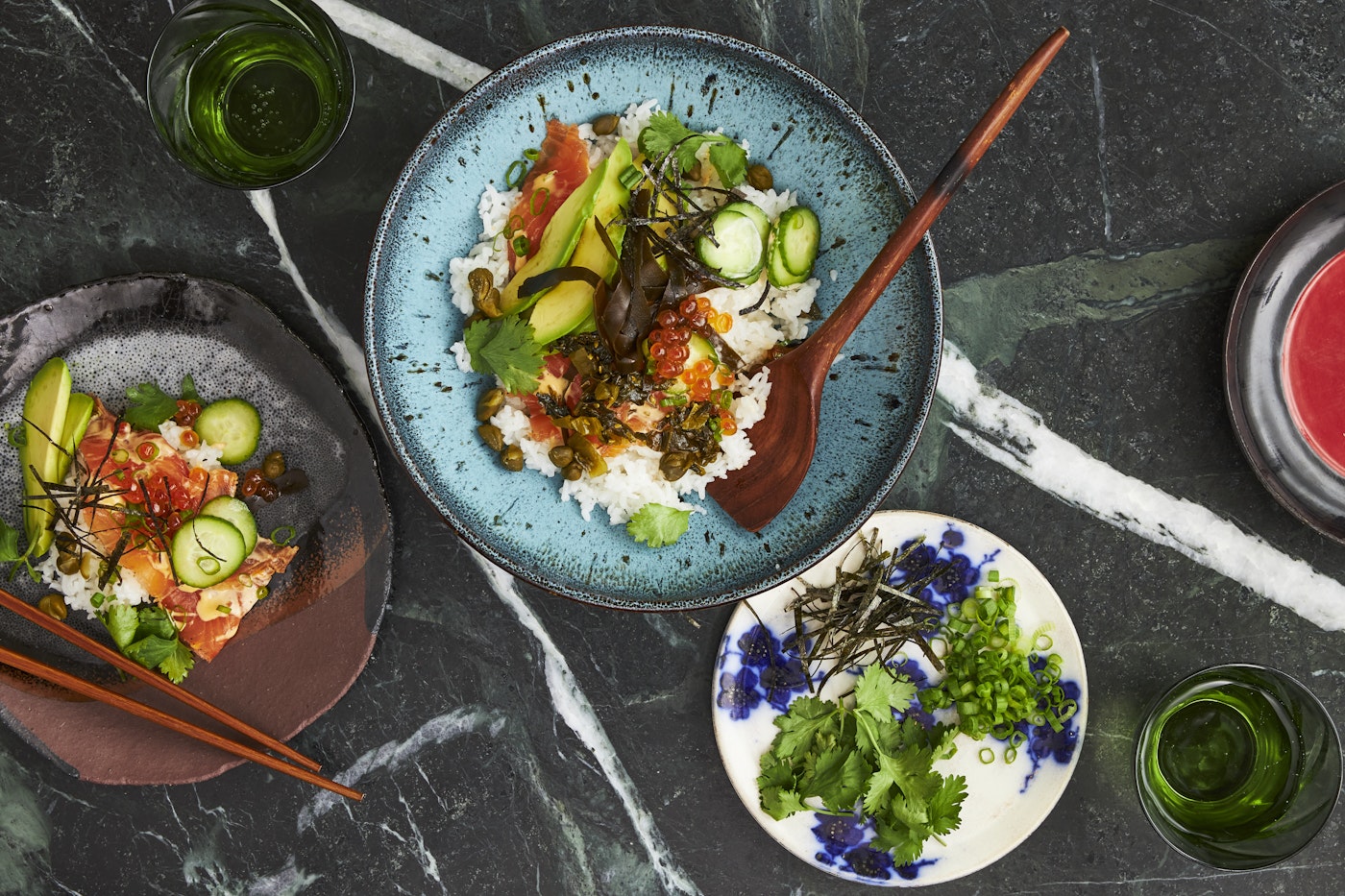 Lox bowl alongside dish of garnishes.