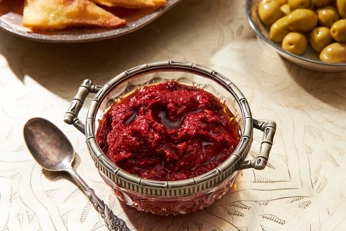 Harissa in a glass bowl, side of marinated olives.